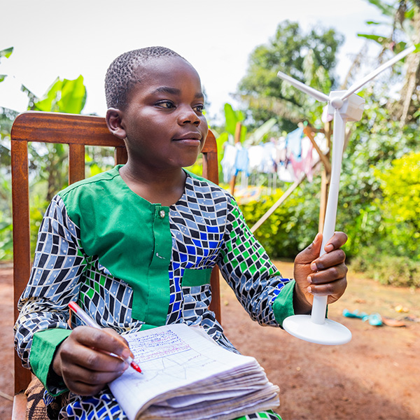 Enfant africain avec ventilateur et bloc-notes